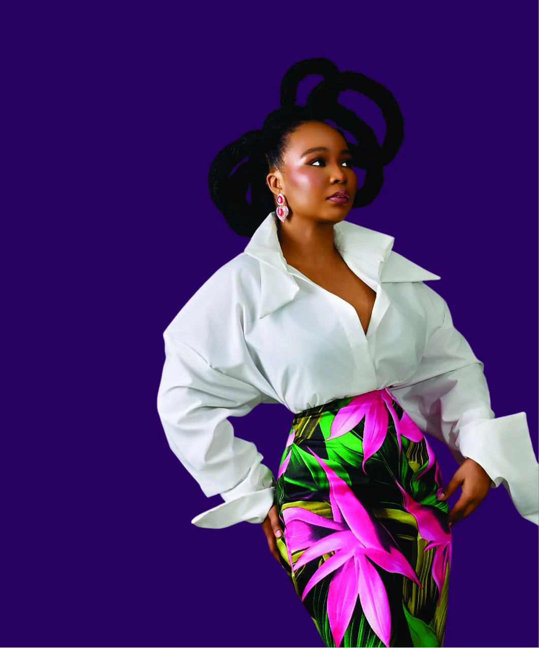 A LadyBeellionaire sister in a white shirt and tropical-print skirt