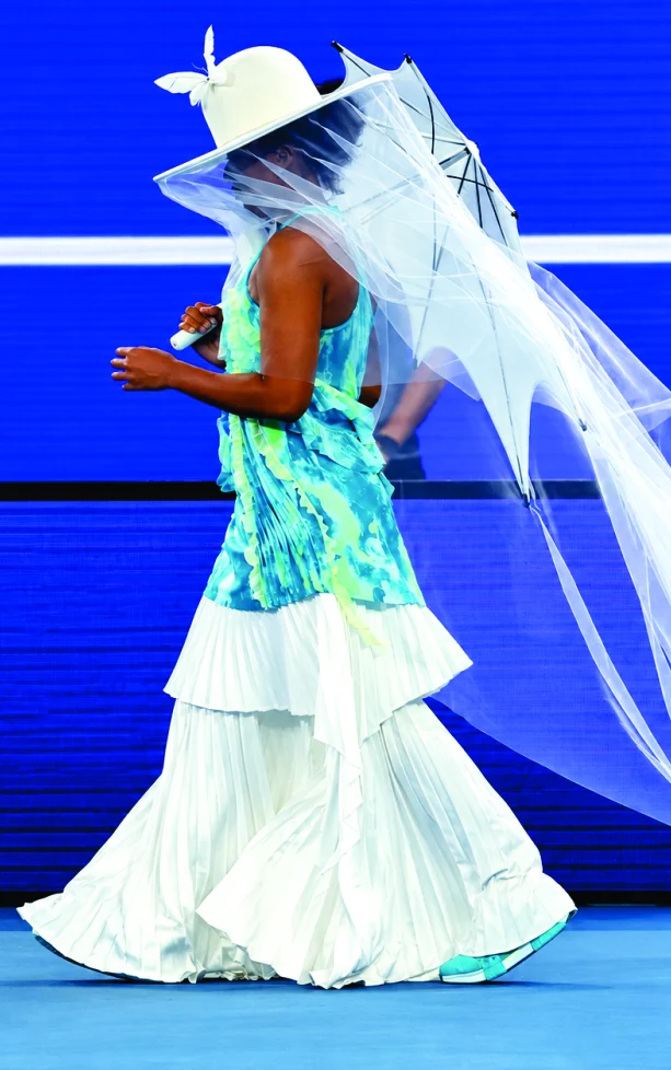 Naomi Osaka in a veiled wide-brim hat and pleated skirt