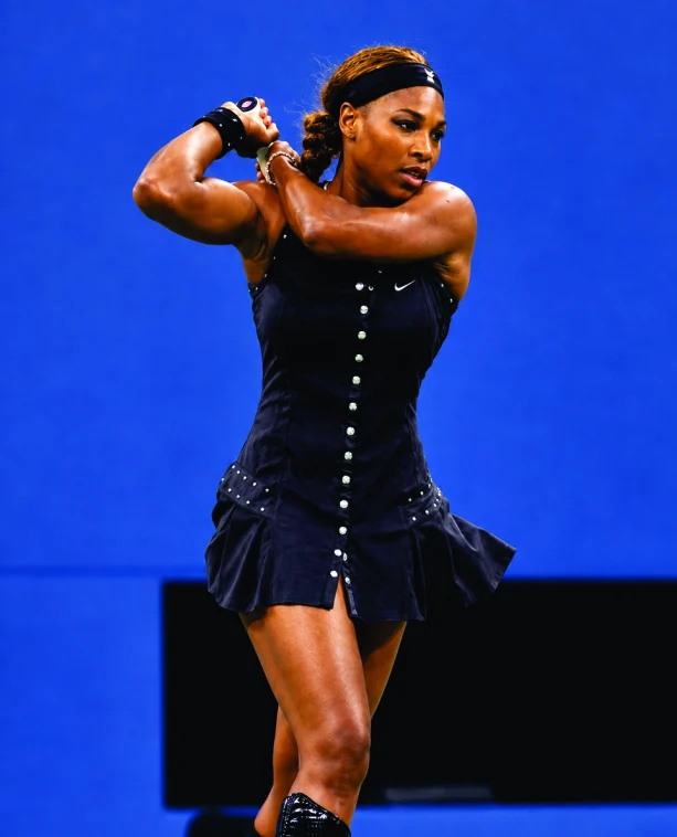 Serena Williams mid-swing in a studded black dress