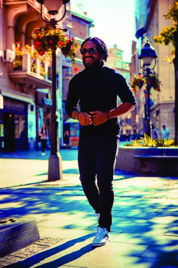 WakaWaka Doctor walking down a sunlit street in Belgrade