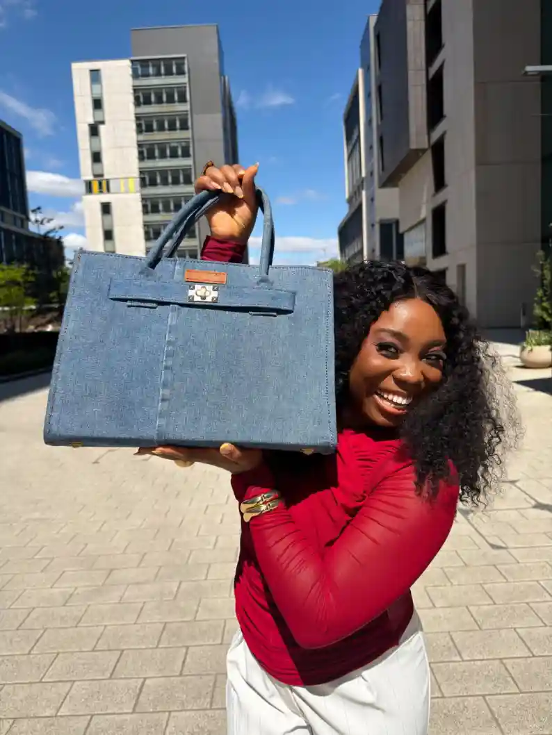 Woman in red top holding a large Tuntunre denim tote bag outdoors