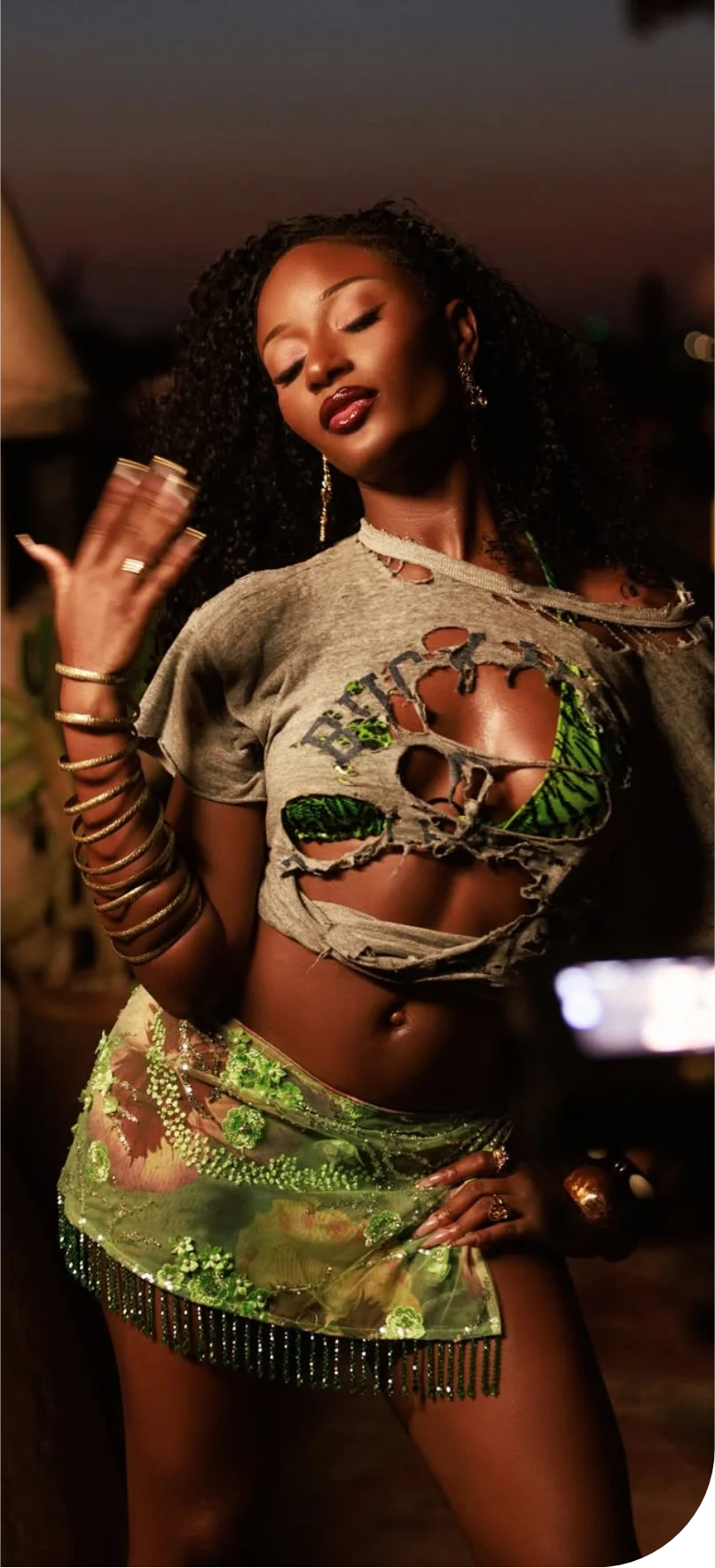 Ayra Starr performing in a glittery green outfit